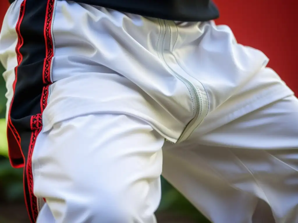 Detalle de pantalones blancos para la práctica de Capoeira, con bordados rojos y negros de alta calidad